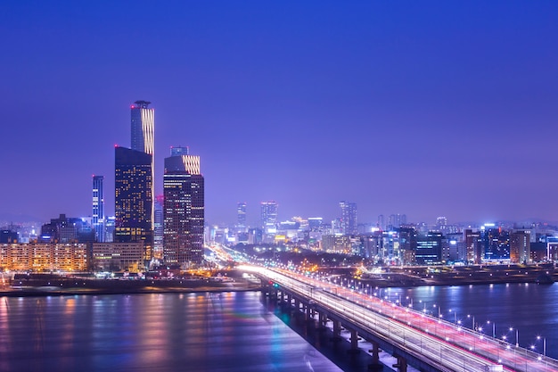 ソウル市と橋と交通、韓国のソウルのダウンタウンで夜の漢江を通過する車。