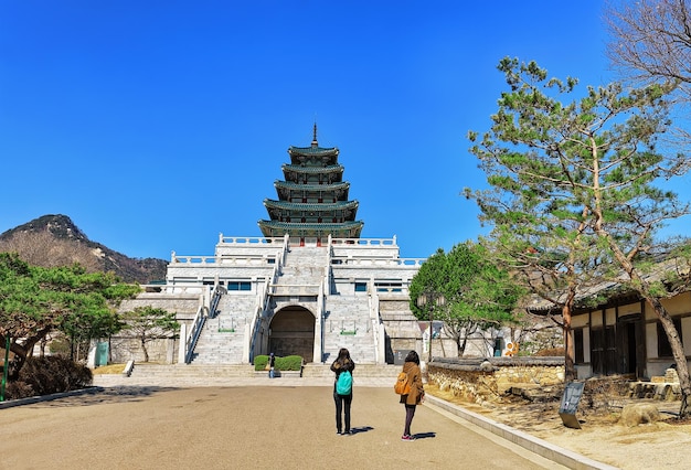 Seoul, south korea - march 11, 2016: tourists taking photo of national folk museum of korea in gyeongbokgung palace in seoul, south korea