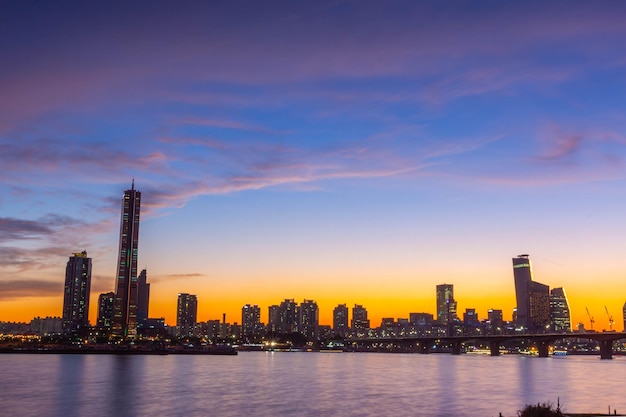 Seoul stad wolkenkrabbers 's nachts langs de rivier de Hangang na zonsondergang bij schemering en de hemel met prachtige kleuren in Yeouido, Zuid-Korea