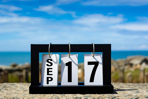 Photo sep 17 calendar date text on wooden frame with blurred background of ocean calendar date concept