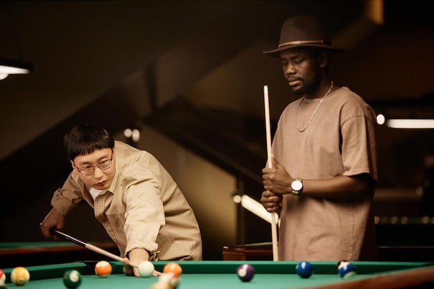 Sepia two men playing pool together