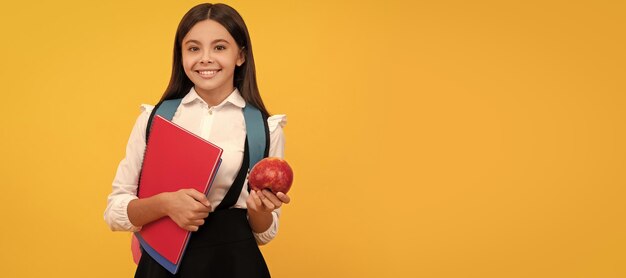 September 1 happy girl hold apple and books school education portrait of schoolgirl student studio banner header school child face copyspace