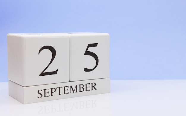 September 25st. Day 25 of month, daily calendar on white table with reflection