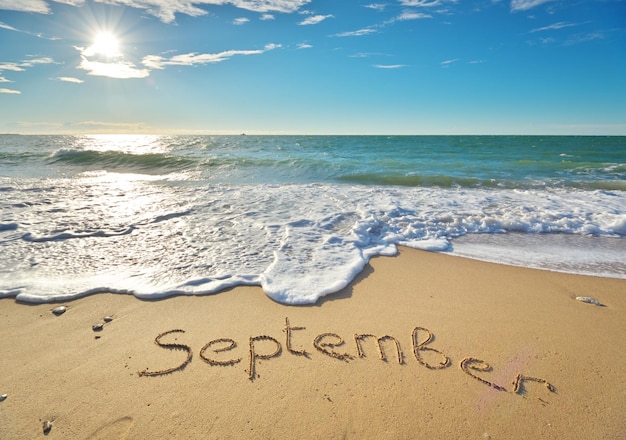 Foto parola di settembre sulla sabbia marina natura cpmposizione