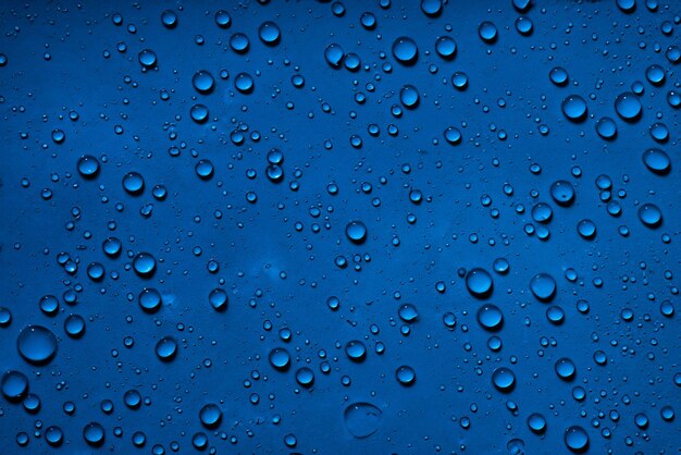 Serene Blue Close Up of Water Droplets on Deep Blue Surface