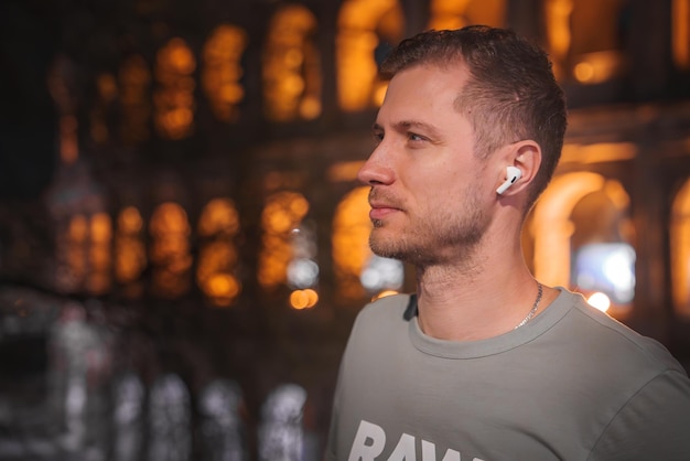 Photo serene man in profile with in ear headphones night