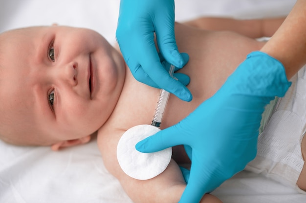 Serene newborn patient being vaccinated by a pediatrician