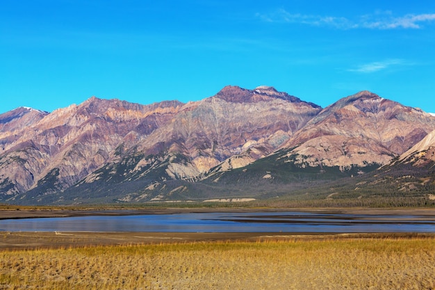 Serene scene by the mountain lake in Canada with reflection of the rocks in the calm water.