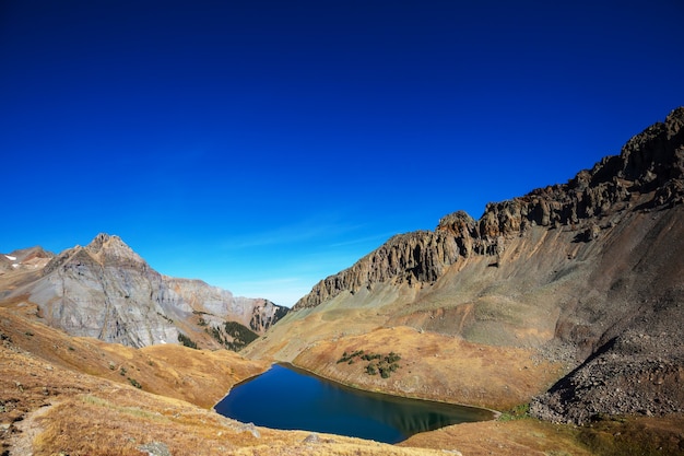Фото Безмятежная сцена у горного озера с отражением скал в спокойной воде.