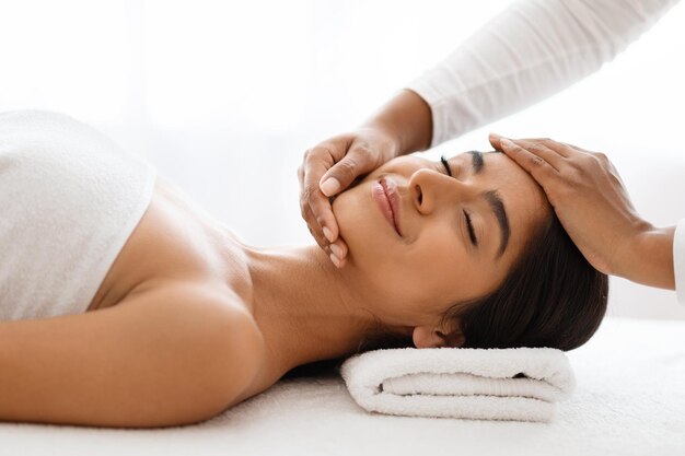 Photo a serene smiling indian lady receives a calming facial rub