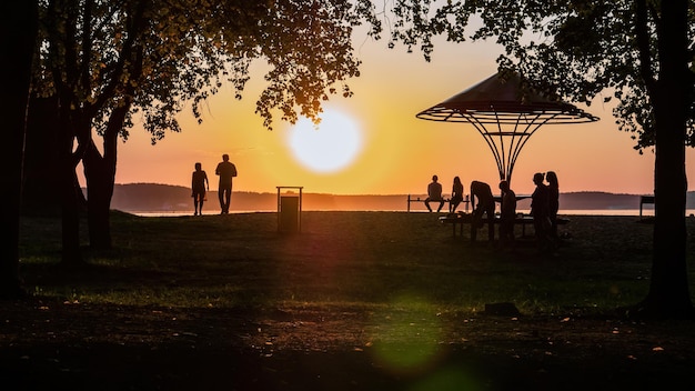 A serene summer sunset on the beach Silhouettes of people walking in the evening