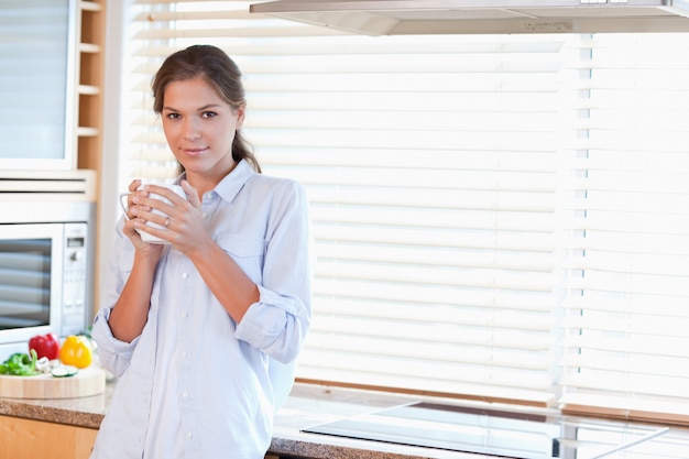 茶のお茶を握っている穏やかな女性