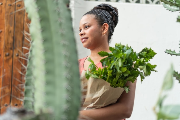 Photo serene woman with fresh greens by cactus garden