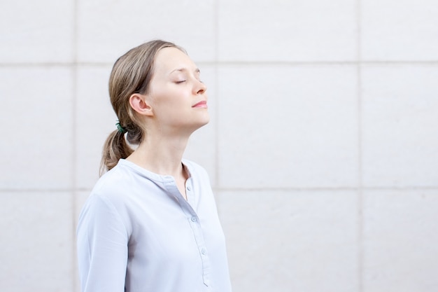 Serene young woman with closed eyes meditating