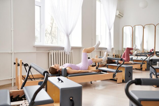 serenity and strength woman laying on a pilates reformer