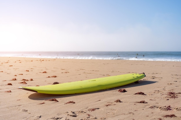 Serf board on the beach View of nice Atlantic ocean beach with sand blue sea and blue sky Holiday and vacation concept