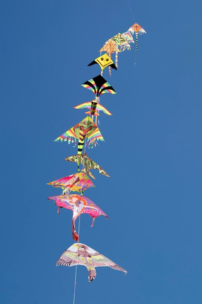 Series of colorful kites flying in the blue sky