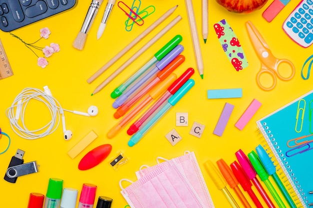 Series of stationery items for kids on yellow background back to school concept flat lay