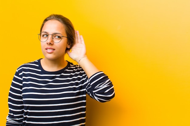 serieus en nieuwsgierig kijken, luisteren, proberen een geheim gesprek of roddel te horen, afluisteren