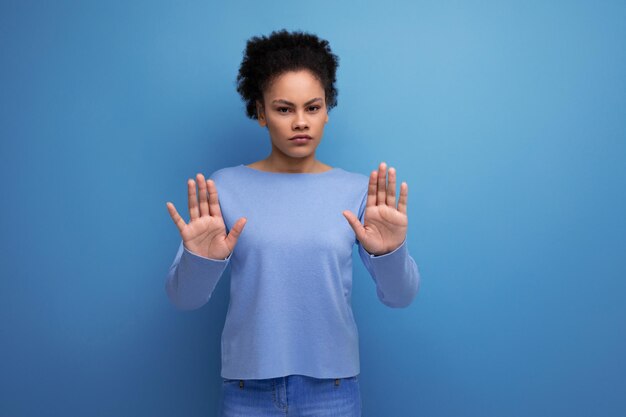 serieuze jonge vrouw in de twintig met afro haar model uiterlijk met stop hand gebaar