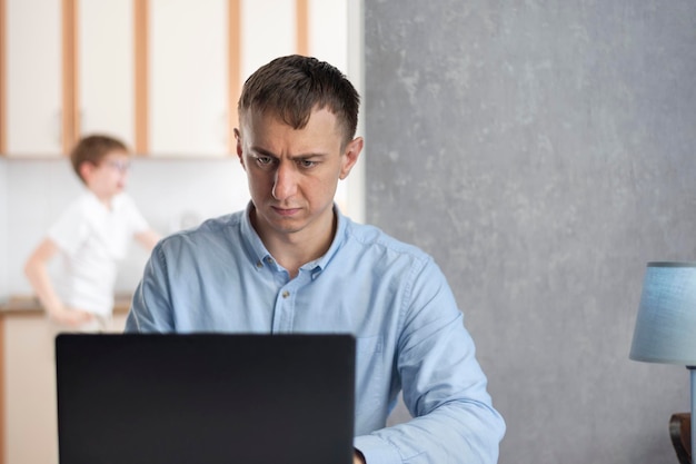 Serieuze man werkt met laptop thuis. Werken op afstand tijdens de pandemie. zzp'er.