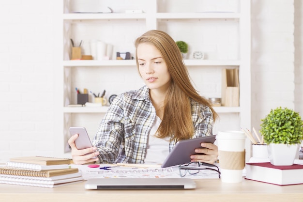 Serieuze vrouw die gadgets gebruikt