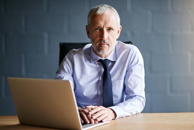 Serious about business Cropped portrait of a mature businessman working in his office