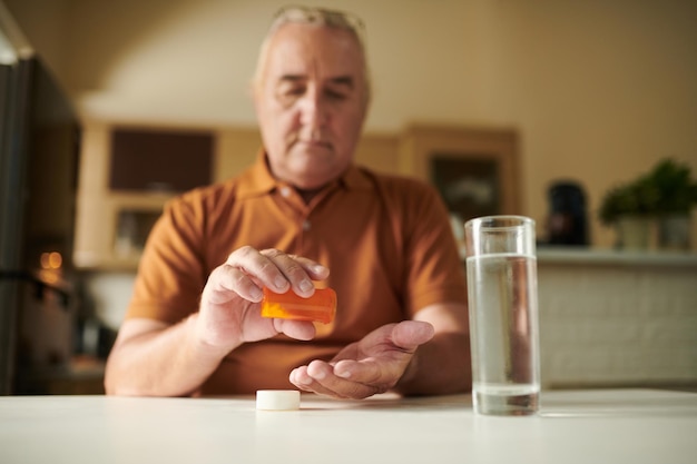 写真 錠剤を服用している深刻な老人