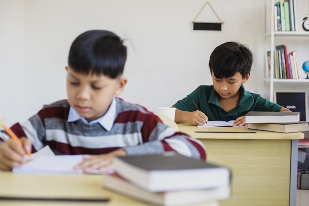 Serious Asian students doing exam in a classroom