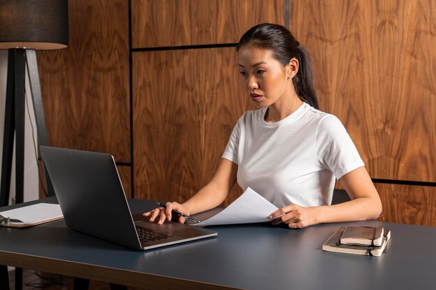 Serious Asian woman typing in office