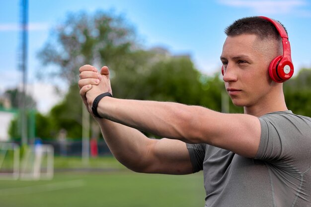 Foto atleta serio stringe le mani con i palmi insieme treni all'aria fresca