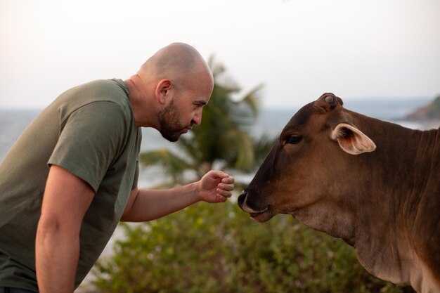 写真 ゼブに傾いて植物の間に立ち、静けさを撫でようと手を差し伸べる深刻なハゲ観光客