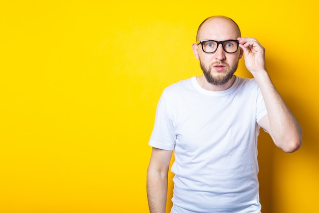 Serious bearded bald young guy with glasses 