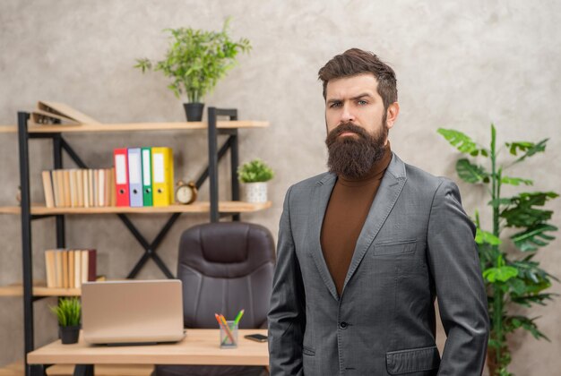 Photo serious bearded businessman wear suit in the office with copy space business