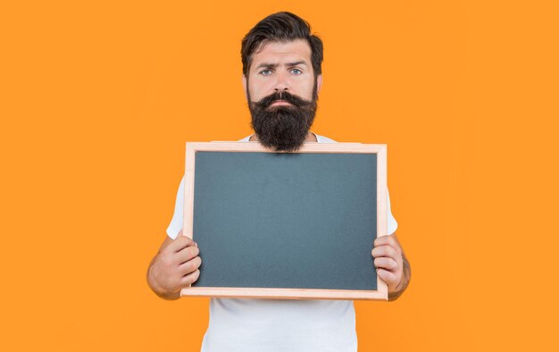 Serious bearded man advertising on blackboard with copy space bearded man advertising