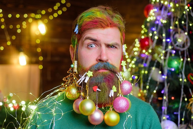 Serious bearded man with decorated beard christmas decorations santa claus man with decorated beard