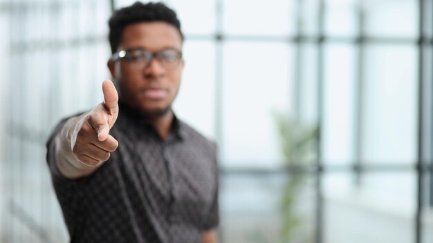 Serious black businessman in glasses pointing at you