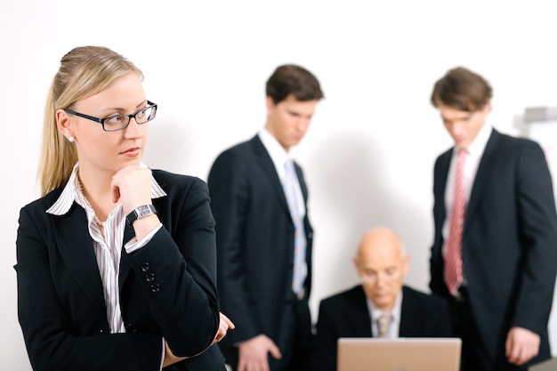 serious blonde businesswoman with blurred people