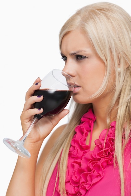 와인 한 잔을 마시는 심각한 금발