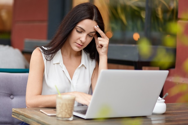 Serious brunette woman thinks on how make startup project correctly