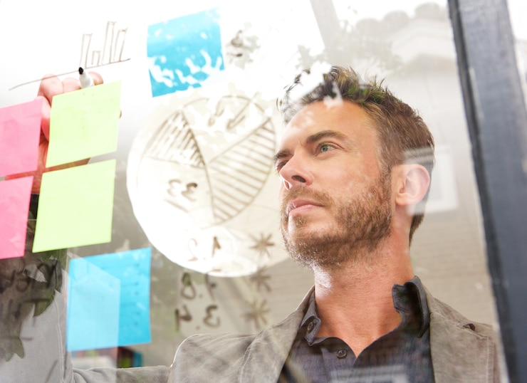 Photo serious business man drawing diagram on idea board