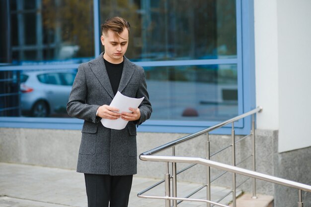 Serious business man reading documents at street