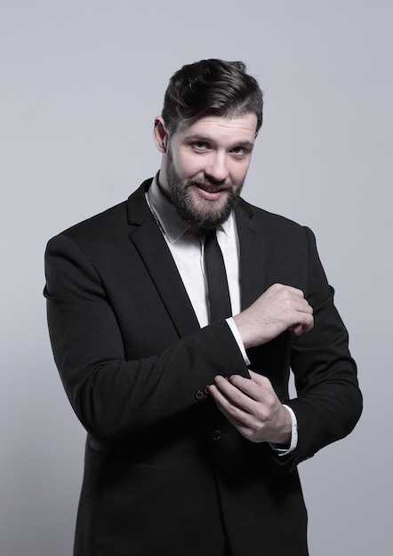 Serious businessman adjusting his cuff link on the sleeve of the shirt