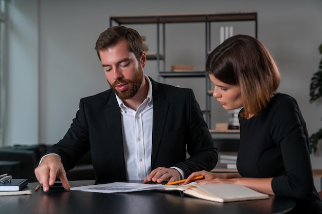 Serious businessman and businesswoman in formal suit discuss contract