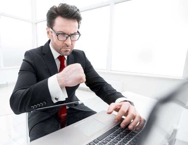 Serious businessman checking accounts while sitting at his Desk