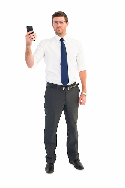 Serious businessman holding his phone