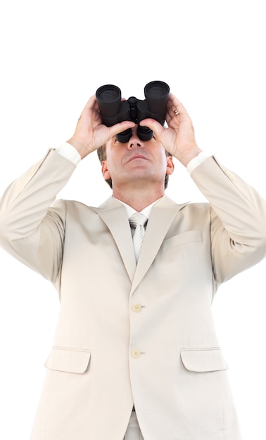 Serious businessman looking through binoculars in front of the camera