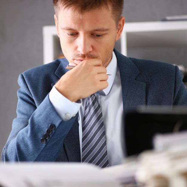 Serious businessman in the office examines documents