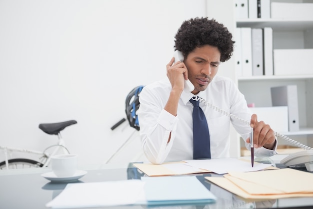 Serious businessman on the phone at desk