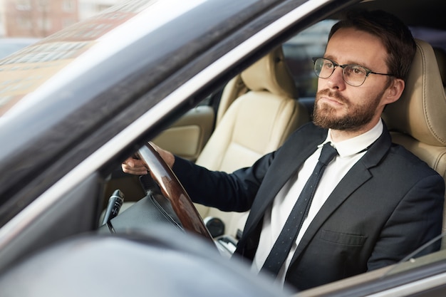 Serious businessman sitting in the car